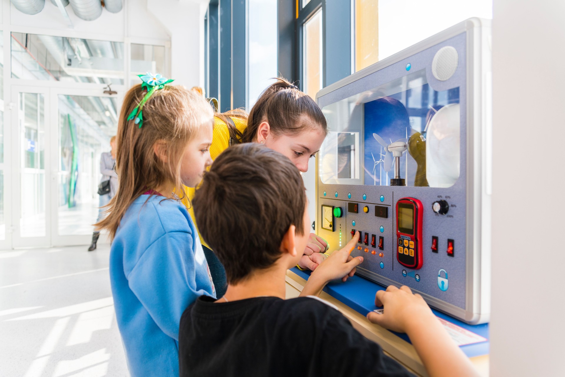 The group of kids of different ages, boys, and girls, exploring exhibition of the Museum of Science and Technology